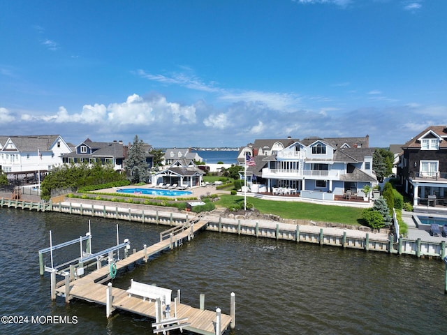 dock area featuring a patio, a lawn, a balcony, and a water view