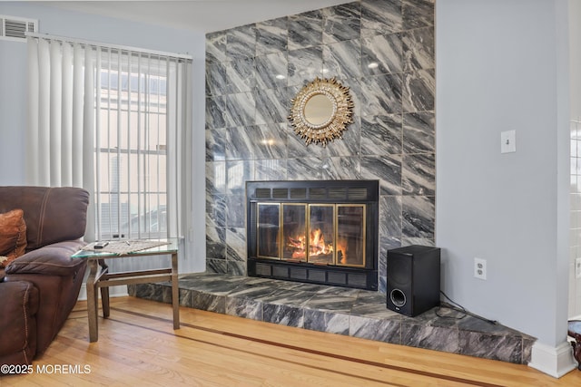 interior details with a tiled fireplace and hardwood / wood-style flooring