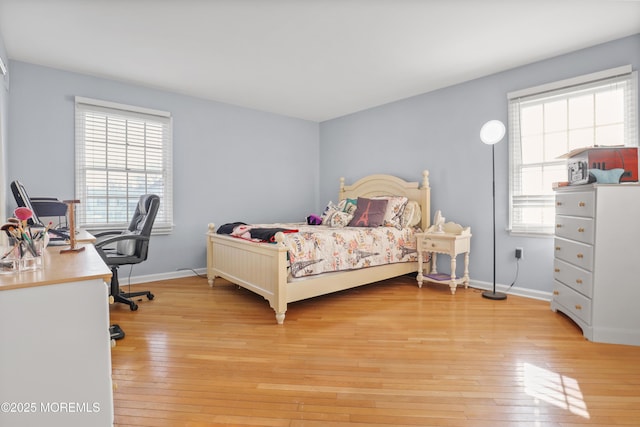 bedroom featuring multiple windows and light wood-type flooring