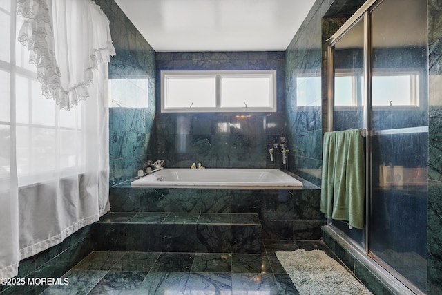 bathroom with tile walls and independent shower and bath