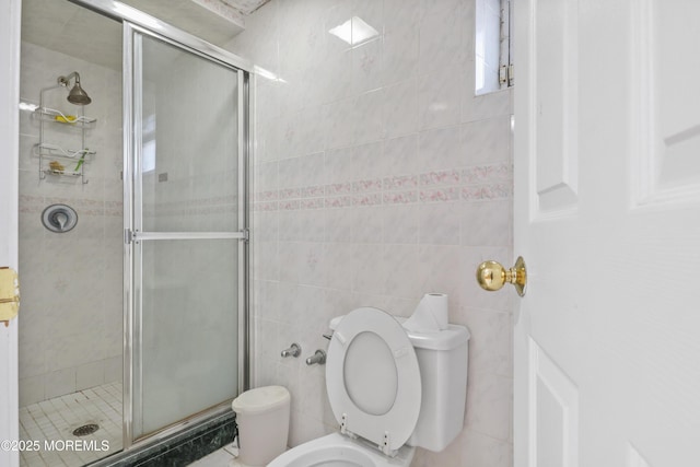 bathroom featuring tile walls, walk in shower, and toilet