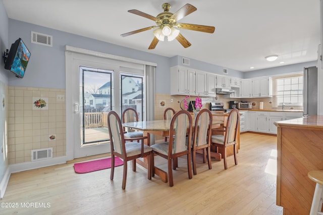 dining room with sink, ceiling fan, and light hardwood / wood-style flooring