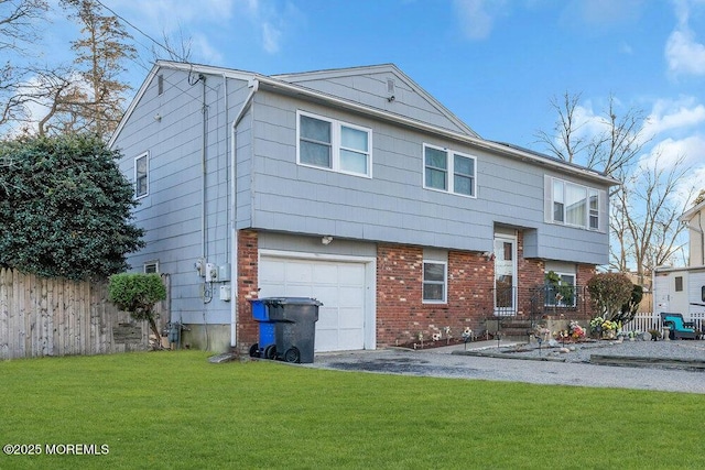 back of house with a garage and a yard