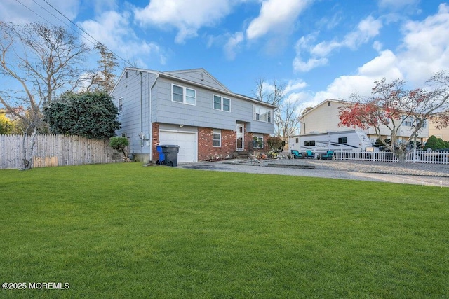 rear view of house featuring a lawn and a garage