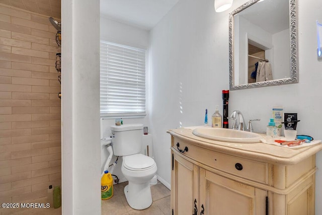 bathroom with toilet, a tile shower, tile patterned flooring, and vanity