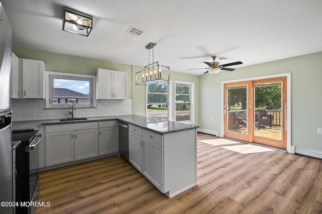 kitchen with sink, dark stone countertops, backsplash, and plenty of natural light