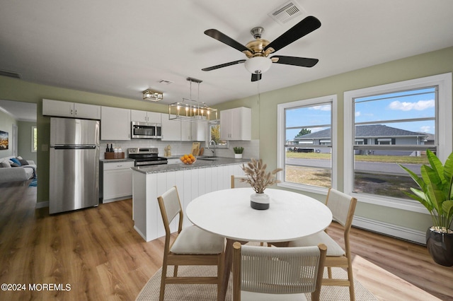 dining space with hardwood / wood-style floors, a wealth of natural light, and sink