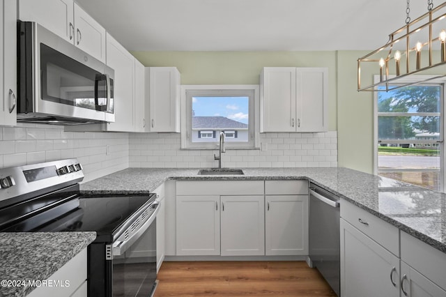 kitchen featuring sink, appliances with stainless steel finishes, tasteful backsplash, and white cabinetry