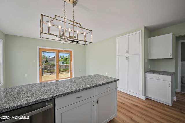 kitchen featuring stainless steel dishwasher, white cabinets, stone counters, and pendant lighting