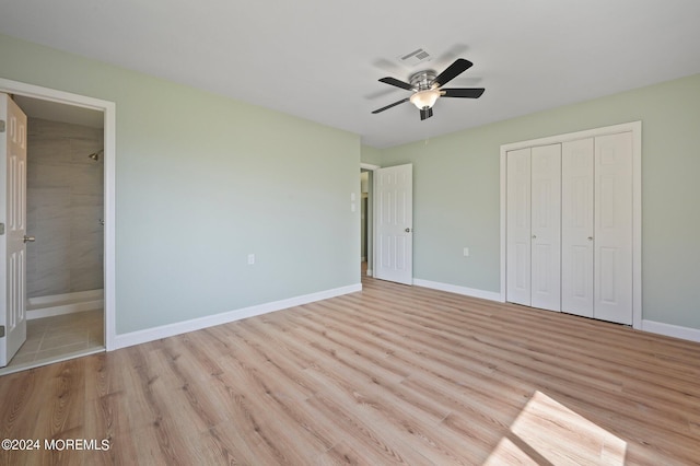 unfurnished bedroom with ceiling fan, light hardwood / wood-style flooring, a closet, and connected bathroom