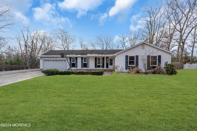 ranch-style house featuring covered porch, a front lawn, and a garage