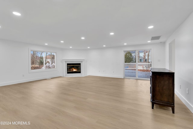 unfurnished living room featuring light hardwood / wood-style flooring and plenty of natural light