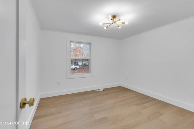 unfurnished room with crown molding, an inviting chandelier, and light hardwood / wood-style flooring