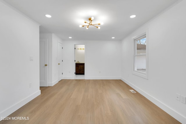 unfurnished room featuring light wood-type flooring, a notable chandelier, and crown molding