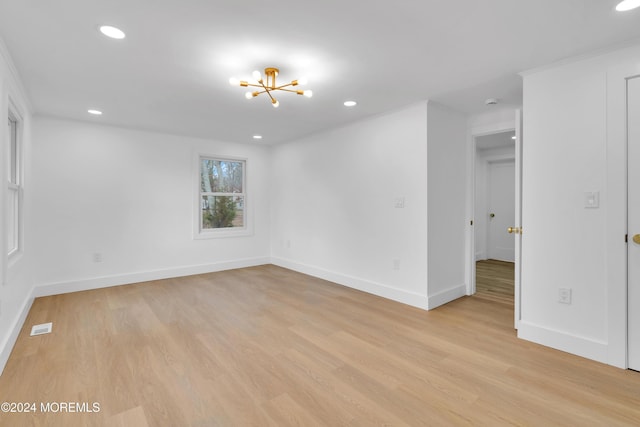 unfurnished room featuring crown molding, an inviting chandelier, and light hardwood / wood-style flooring