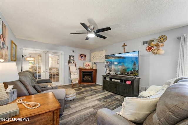 living room featuring french doors, a textured ceiling, hardwood / wood-style floors, and ceiling fan