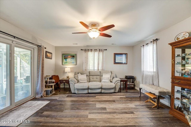 living room featuring dark hardwood / wood-style flooring, ceiling fan, and a wealth of natural light