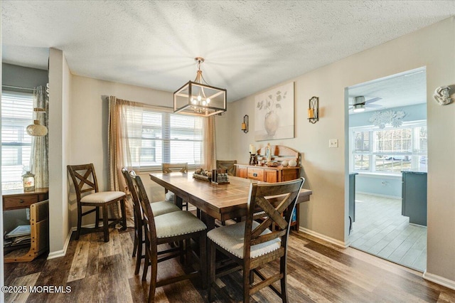 dining area with a textured ceiling, a notable chandelier, and hardwood / wood-style floors