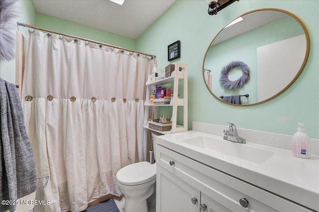 bathroom featuring a textured ceiling, a shower with shower curtain, vanity, and toilet