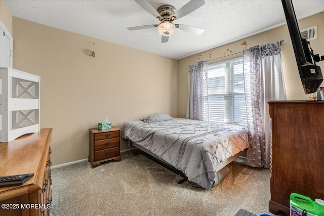 bedroom with light carpet, ceiling fan, and a textured ceiling