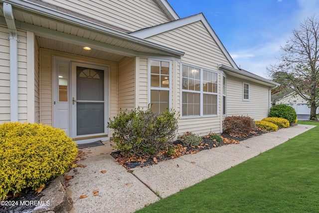 property entrance featuring a lawn