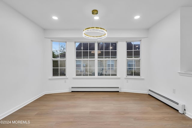 unfurnished dining area featuring light hardwood / wood-style floors and baseboard heating