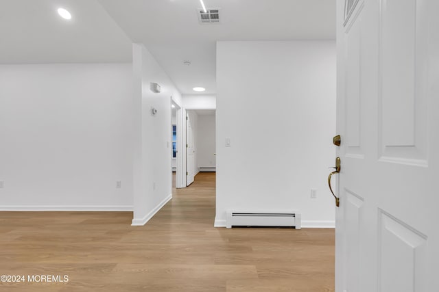 hall featuring a baseboard radiator and light hardwood / wood-style floors