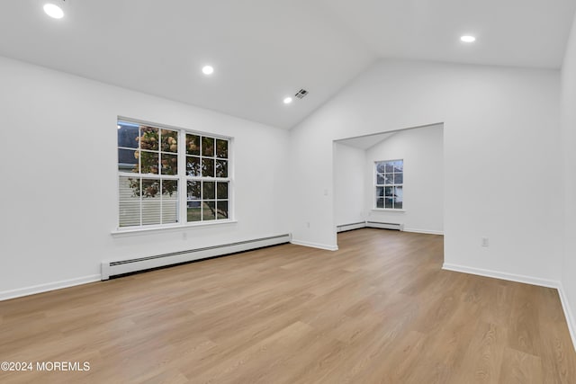 interior space with light hardwood / wood-style floors, vaulted ceiling, and a baseboard radiator