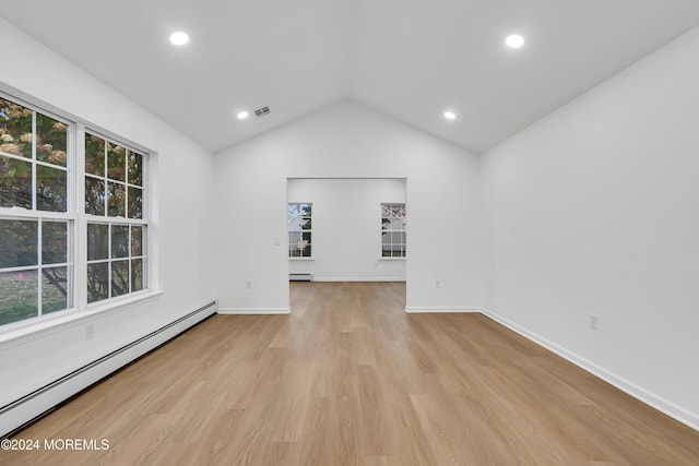 empty room featuring a baseboard radiator, vaulted ceiling, and light hardwood / wood-style flooring