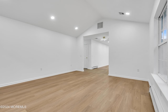 unfurnished living room with lofted ceiling, a baseboard heating unit, and light hardwood / wood-style floors