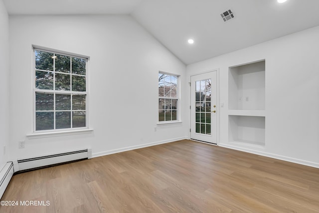 empty room with light wood-type flooring, built in features, vaulted ceiling, and a baseboard heating unit