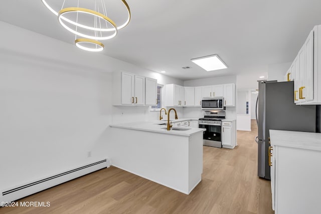 kitchen featuring baseboard heating, appliances with stainless steel finishes, pendant lighting, sink, and white cabinetry