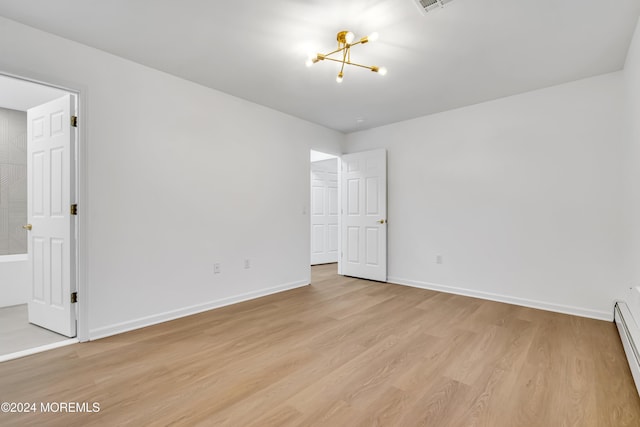 spare room with a baseboard radiator and light wood-type flooring