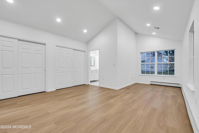 unfurnished bedroom featuring a baseboard radiator, two closets, connected bathroom, and light hardwood / wood-style floors