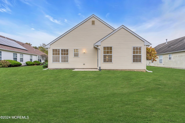 back of property with a yard and a patio