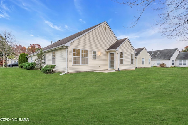 back of house with a patio area and a yard