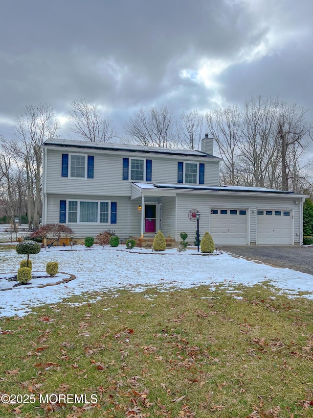 view of front property featuring a garage and a front yard