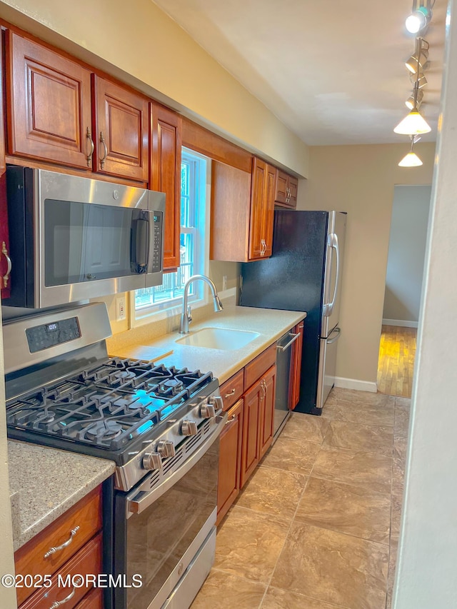 169 Docare Rd, Jackson, NJ 08527 - kitchen featuring appliances with stainless steel finishes, brown cabinetry, a sink, and track lighting