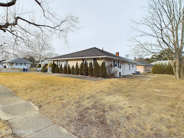 view of side of home featuring a lawn and cooling unit