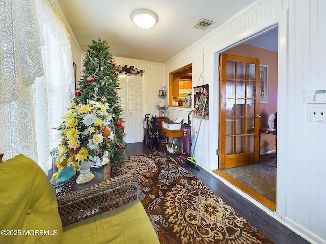 hallway with dark wood-type flooring and ornamental molding