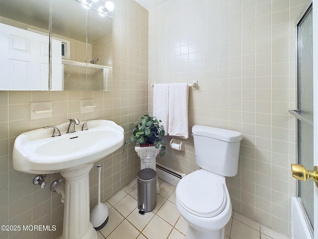 bathroom featuring tile walls, baseboard heating, toilet, and tile patterned floors