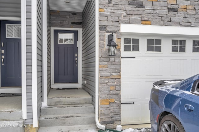 view of exterior entry featuring a garage and washer / clothes dryer