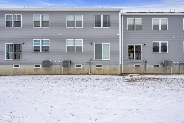 snow covered property featuring a wall mounted AC and central AC