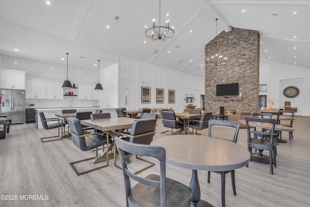 dining room with high vaulted ceiling, light hardwood / wood-style floors, beam ceiling, and a chandelier