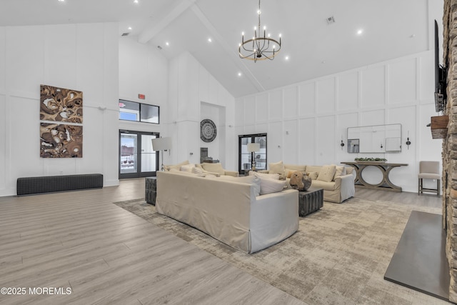 living room featuring high vaulted ceiling, an inviting chandelier, beamed ceiling, and light wood-type flooring