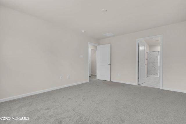 unfurnished bedroom featuring ensuite bathroom and light colored carpet