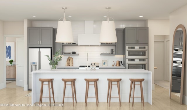 kitchen with hanging light fixtures, a breakfast bar, gray cabinetry, and high end fridge