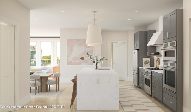 kitchen featuring gray cabinets, high end appliances, pendant lighting, and a breakfast bar area