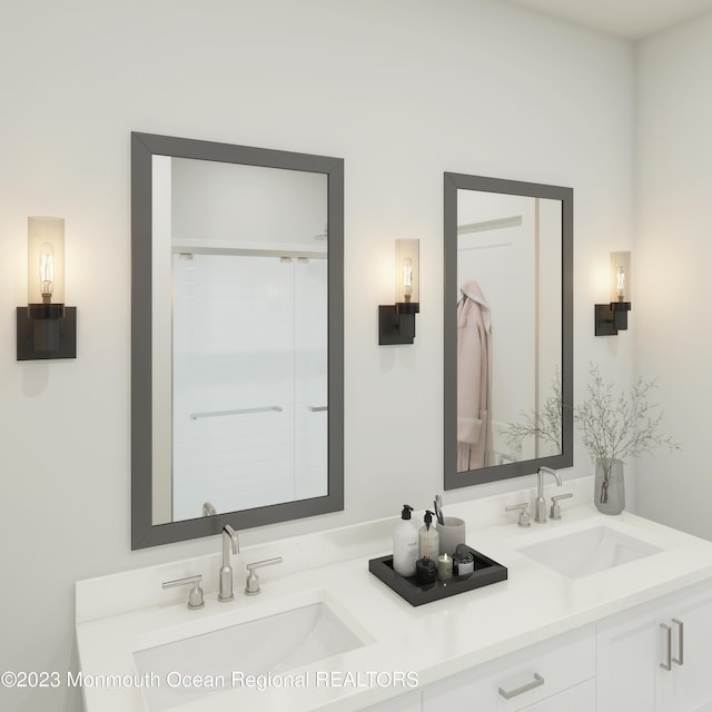 bathroom featuring a shower with door and vanity