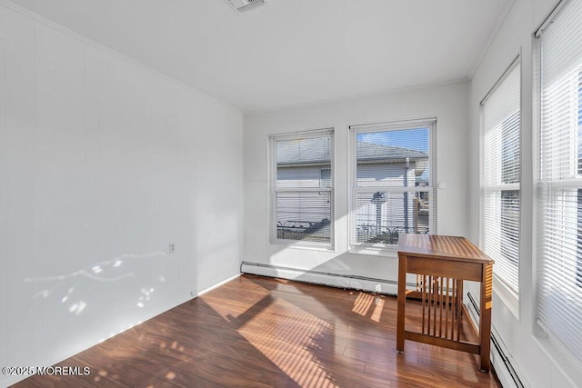 dining space with hardwood / wood-style flooring, ornamental molding, and a baseboard heating unit